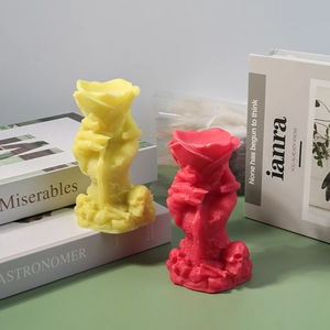 Detailed view of hand-shaped Halloween candle with skull base and rose on a green surface