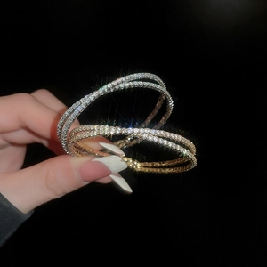 Gros plan de bracelets croisés dorés et argentés ornés de zircons cubiques scintillants