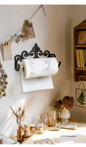 Detail eines Vintage-Küchenrollenhalters aus Gusseisen mit Lilienmuster an der Wand