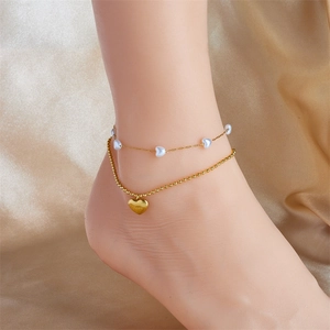 Detail of double-layer anklet with white heart beads and gold Love heart pendant