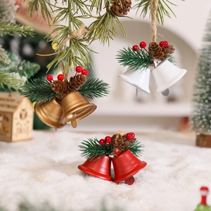Detail of Christmas metal bells with pine cones and berries on snowy background