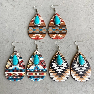 Detail of three pairs of teardrop ethnic earrings with turquoise inlay and boho patterns