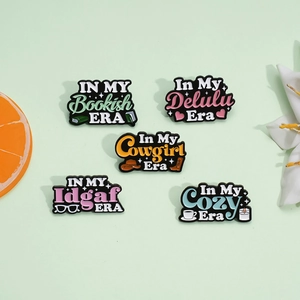 Set of five colorful enamel pins with motivational In My Era quotes and icons