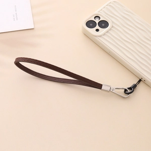 Detail of brown PU leather phone wrist strap with stitching and silver metal clasp