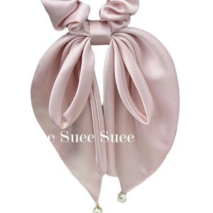 Elegant pink silk bow hair scrunchie with white pearl charms on white background