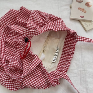 Internal view showing zipper pocket and spacious storage in a red gingham tote bag