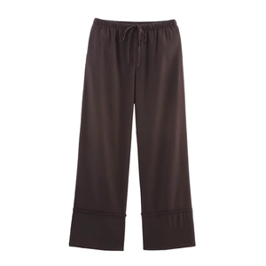 Detail of dark brown linen trousers with drawstring elastic waist and wide folded hems