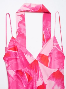 Detail eines rückenfreien Kleides mit rosa-rotem Druck, V-Ausschnitt und Neckholder