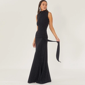 Détail d'une robe de soirée noire à paillettes, col montant sans manches avec nœud de taille