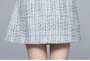 Detail view of blue tweed fabric texture with intricate embroidery and woven pattern