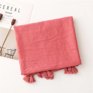 Detail of coral cotton scarf with subtle glitter shimmer and tassel edge trim