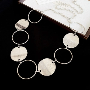 Close-up of silver metal waist chain featuring polished rings and brushed texture discs