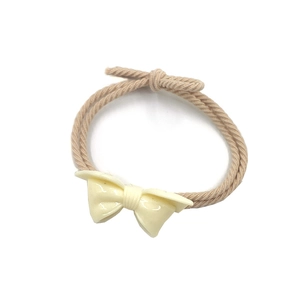 Detail of a creamy white resin bow on a khaki braided elastic hair tie hair accessory