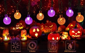 Close-up of waterproof solar crystal ball lights with purple and orange Halloween bulbs