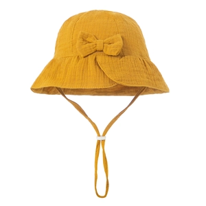 Detail of baby cotton sun hat in yellow with decorative bow and adjustable chin strap