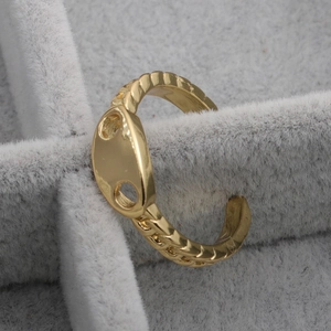Gold oval pig nose ring with textured twist band displayed in a grey jewelry box