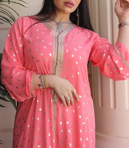 Robe caftan ethnique rose avec motifs dorés et décolleté en V présentée sur mannequin