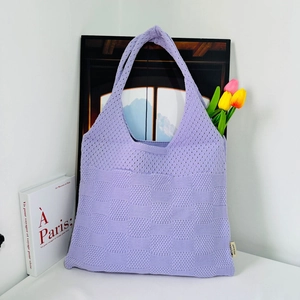 Detailed close-up of purple knit tote bag showing intricate hollow crochet texture
