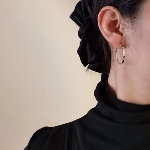 Close-up of minimalist S925 sterling silver hoop earrings with textured floral pattern