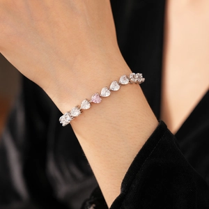 Détail du bracelet en argent avec zircons en forme de cœur et une pierre rose pâle
