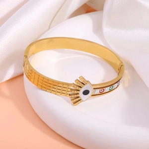 Detail of gold evil eye bangle featuring colorful enamel on textured stainless steel