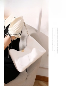 Detail view of white PU leather shoulder bag with embossed chevron pattern and gold zipper