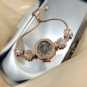 Detail of rose gold bracelet watch with crystal accents on reflective tray