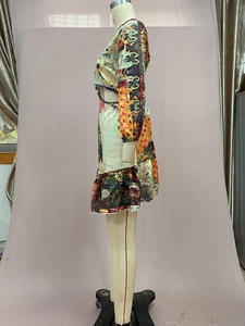 Detail view of dress with side cut-out, ruffle hem, and vibrant scenic landscape prints