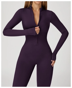 Detail of dark purple thermal yoga jumpsuit featuring zip collar and functional thumbholes