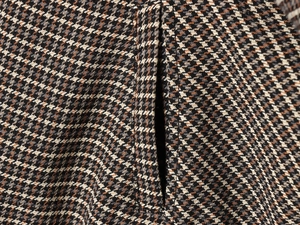 Close-up of brown and beige houndstooth fabric texture on a casual fashion jacket