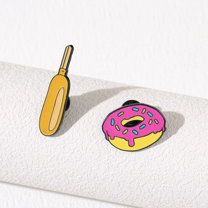 Creative enamel pins featuring a hot dog and a pink doughnut made of polished metal