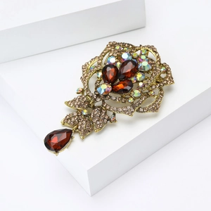Detailed view of elegant rose brooch with brown rhinestones and golden metal finish