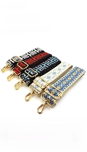 Close-up of ethnic style jacquard shoulder straps with gold metal hooks for handbags