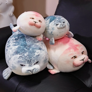 Soft cartoon seal plush toy dolls in pink and grey colors on a black leather sofa