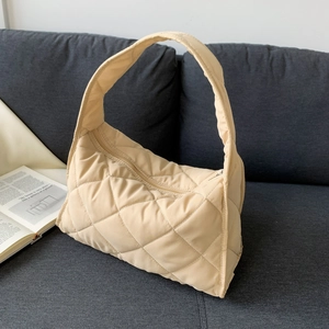 Close-up of beige quilted nylon shoulder bag with a soft down-cotton texture and zip closure