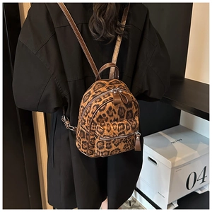 Detalle de mini mochila con estampado de leopardo, cremalleras y correas de cuero
