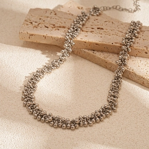 Detail of silver beaded necklace with intricate metal textures and adjustable link chain