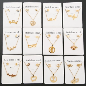 Golden stainless steel jewelry sets with heart, star and butterfly pendants on display cards