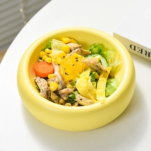 Creamy yellow ceramic donut-shaped bowl for salad and cereal with smooth round finish