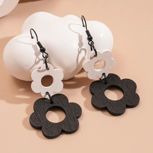 Close-up of bohemian wood hollow flower earrings with black and white layered design