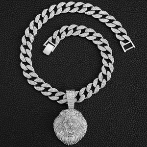 Détail de la chaîne cubaine argentée avec pendentif tête de lion givrée sur fond cuir noir
