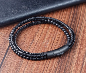 Macro detail of men's multilayer braided leather bracelet with matte magnetic clasp