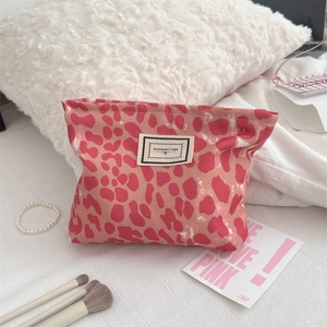 Dettaglio della borsa trucco con stampa leopardata rosa ed etichetta PLEASANT TIME