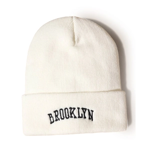 Close-up of Brooklyn black embroidery on a white ribbed knit beanie for winter