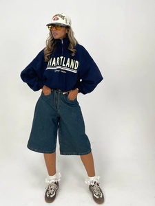 Detail of navy blue half-zip sweatshirt with letter print and oversized denim shorts