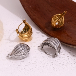 Detail of 18K gold plated hoop earrings with striped texture and white pearls