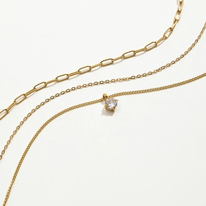 Détail de la chaîne trombone plaquée or 18k et pendentif zircon sur collier à trois rangs