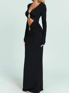 Elegant black long-sleeved maxi dress with cutout waist and gold metal hardware