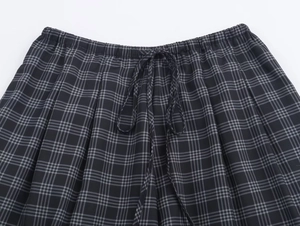Detail of grey plaid shorts featuring elastic waistband and adjustable matching drawstring