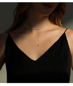 Detailed view of sterling silver Y-shaped star necklace on neck with lighting